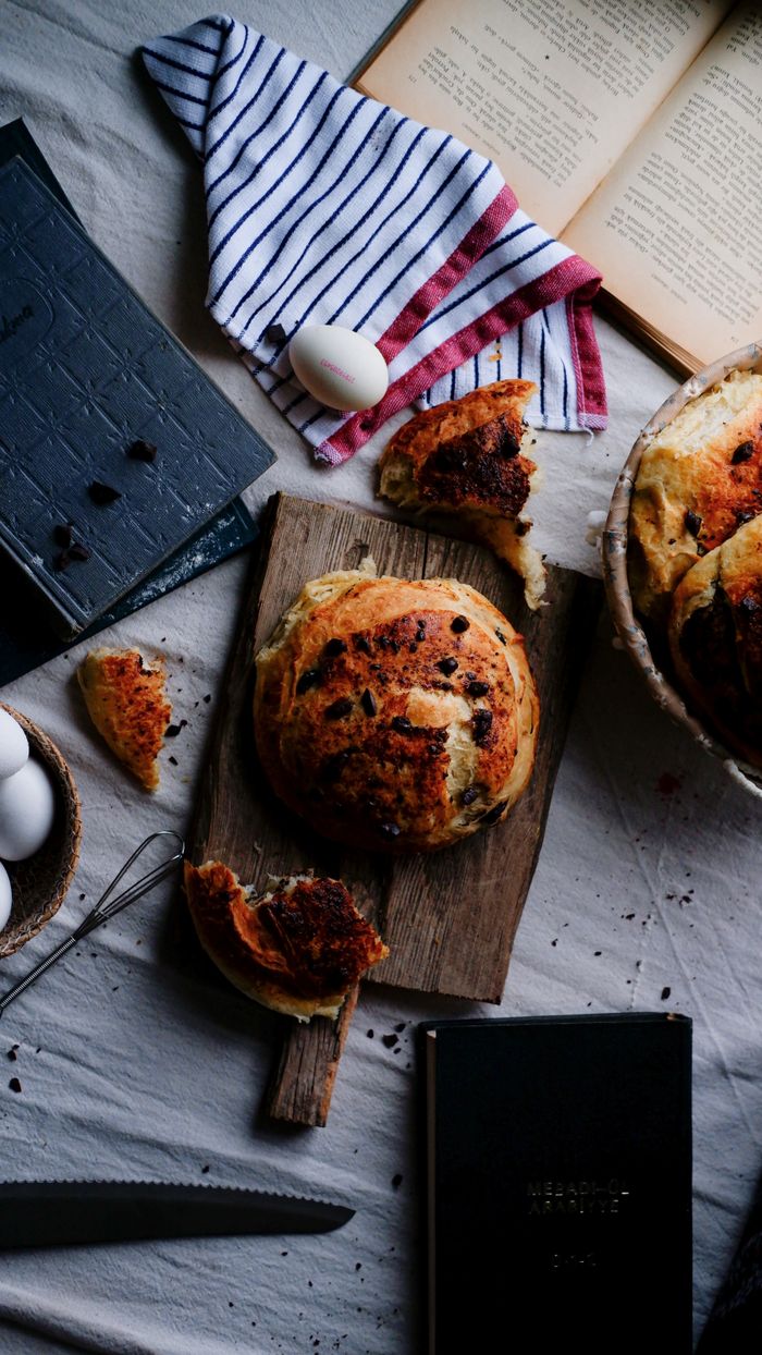 Mastering the First Impression: Your intriguing post title goes here A cozy baking scene featuring round bread, eggs, and recipe books on a rustic table setup.