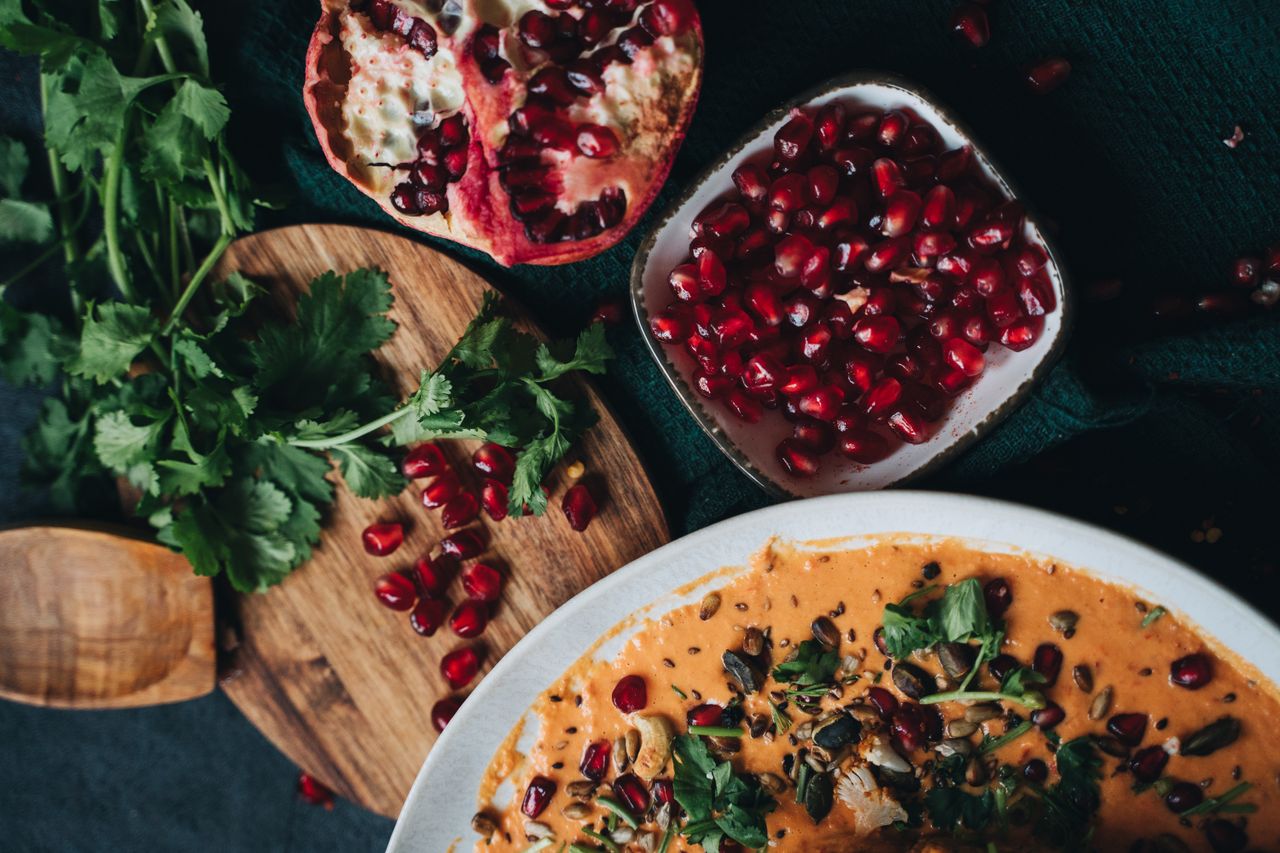 our-story Delicious vegan dish garnished with pomegranate and fresh cilantro, perfect for fall dining.